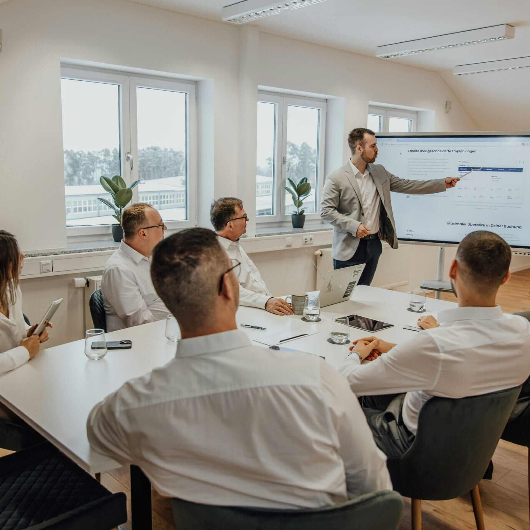 man presenting a slide of data to his team