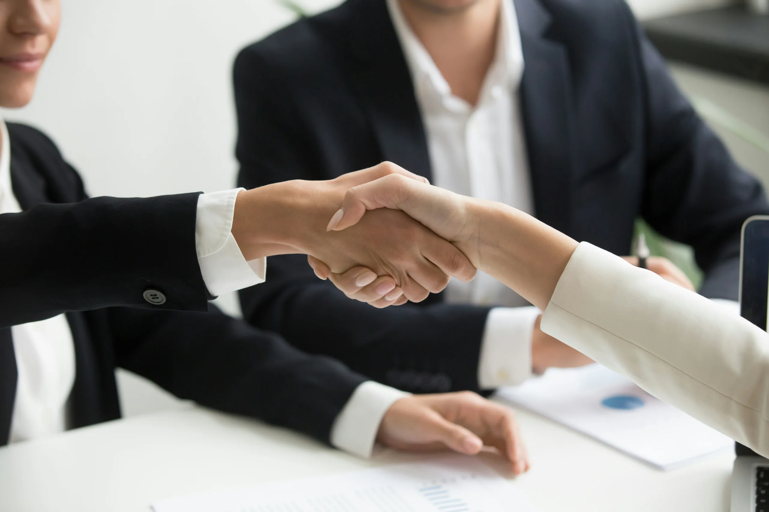 two business people shaking hands over the table
