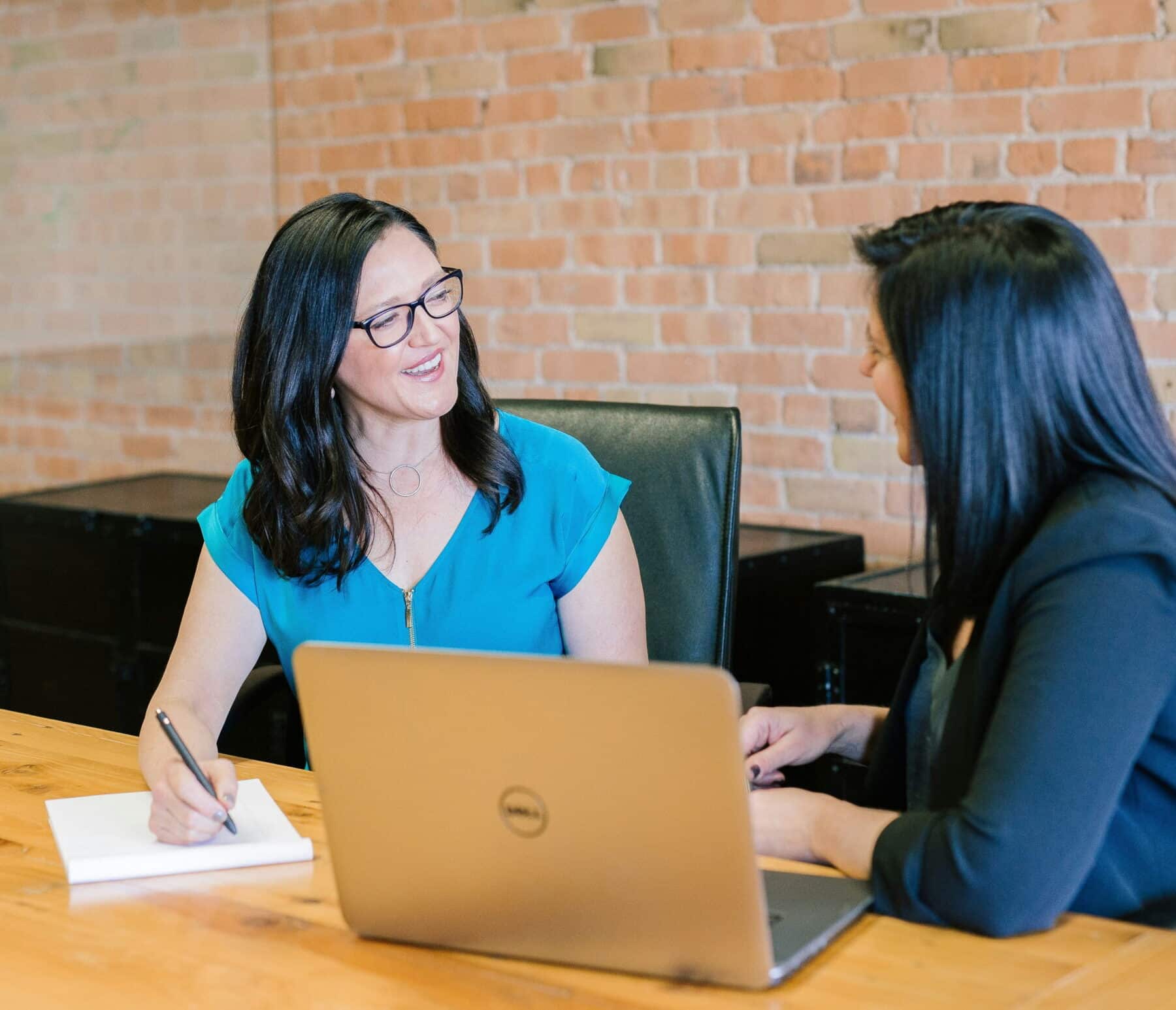 two women working together in conference room