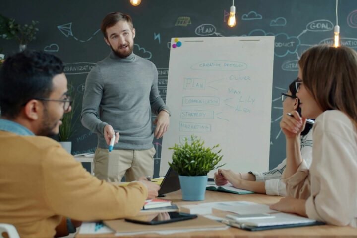 man presenting to team in conference room